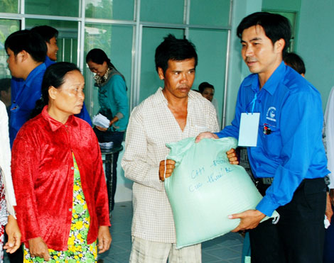 Đồng chí Tô Thế Anh, Phó Bí thư Đoàn khối các cơ quan tỉnh Bạc Liêu trao tặng gạo cho các hộ nghèo tại xã Vĩnh Phú Đông, huyện Phước Long.